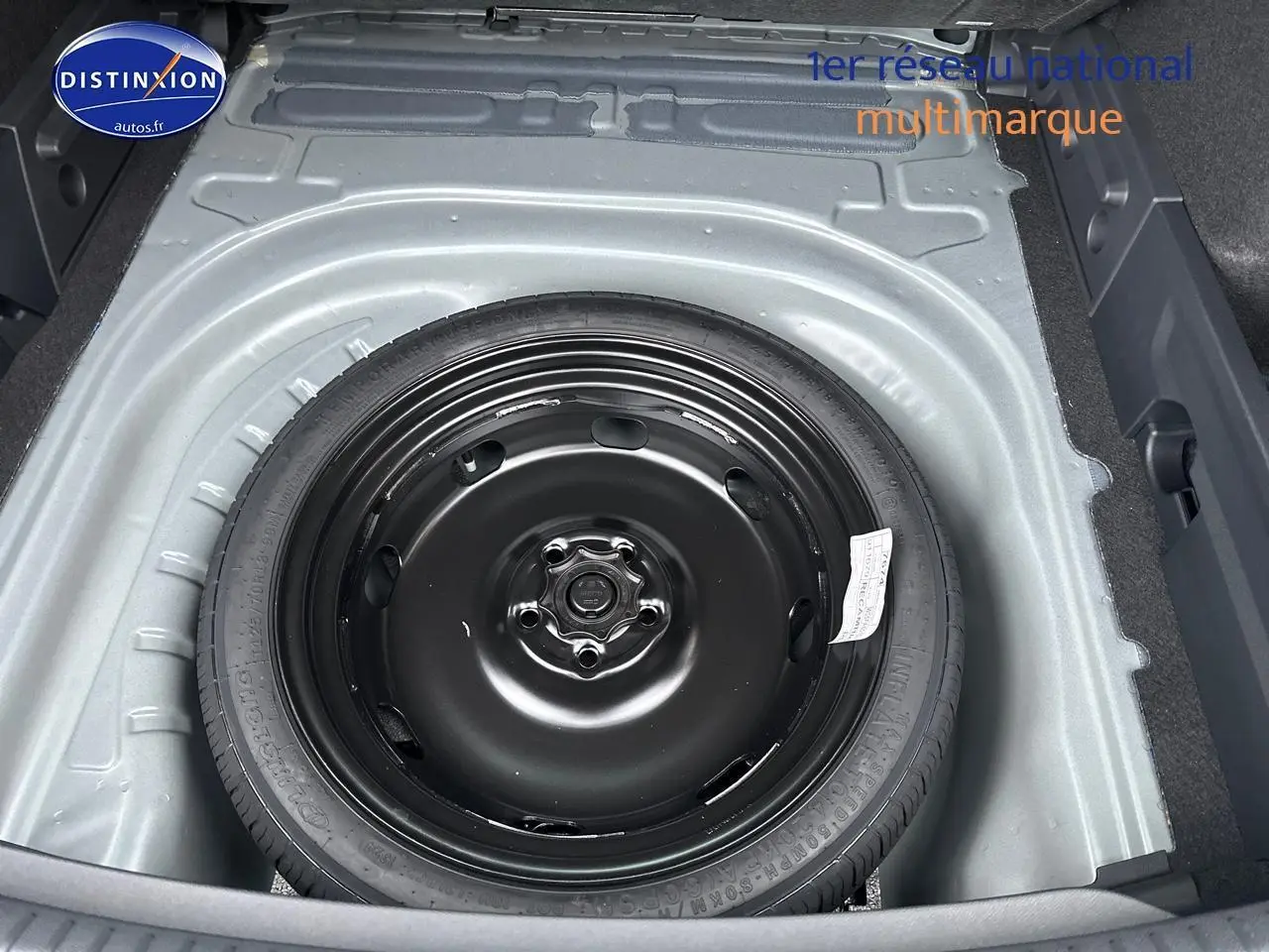 Vue plongeante sur la roue de secours noire dans le coffre gris magnétique de la CUPRA LEON ST 2025.