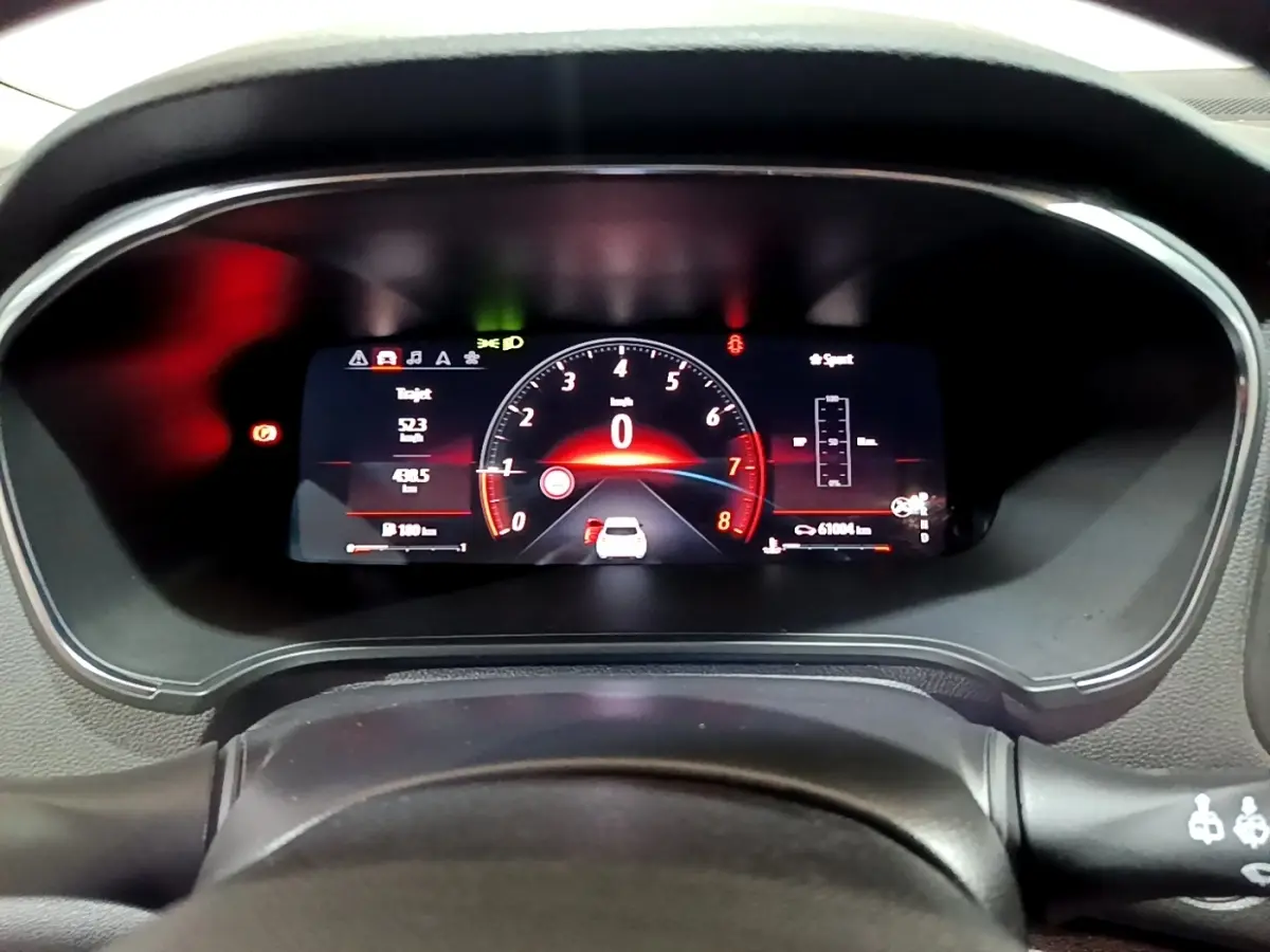 Gros plan sur le combiné d'instruments numérique de la Renault Mégane 2023, affichage rouge et noir sportif.