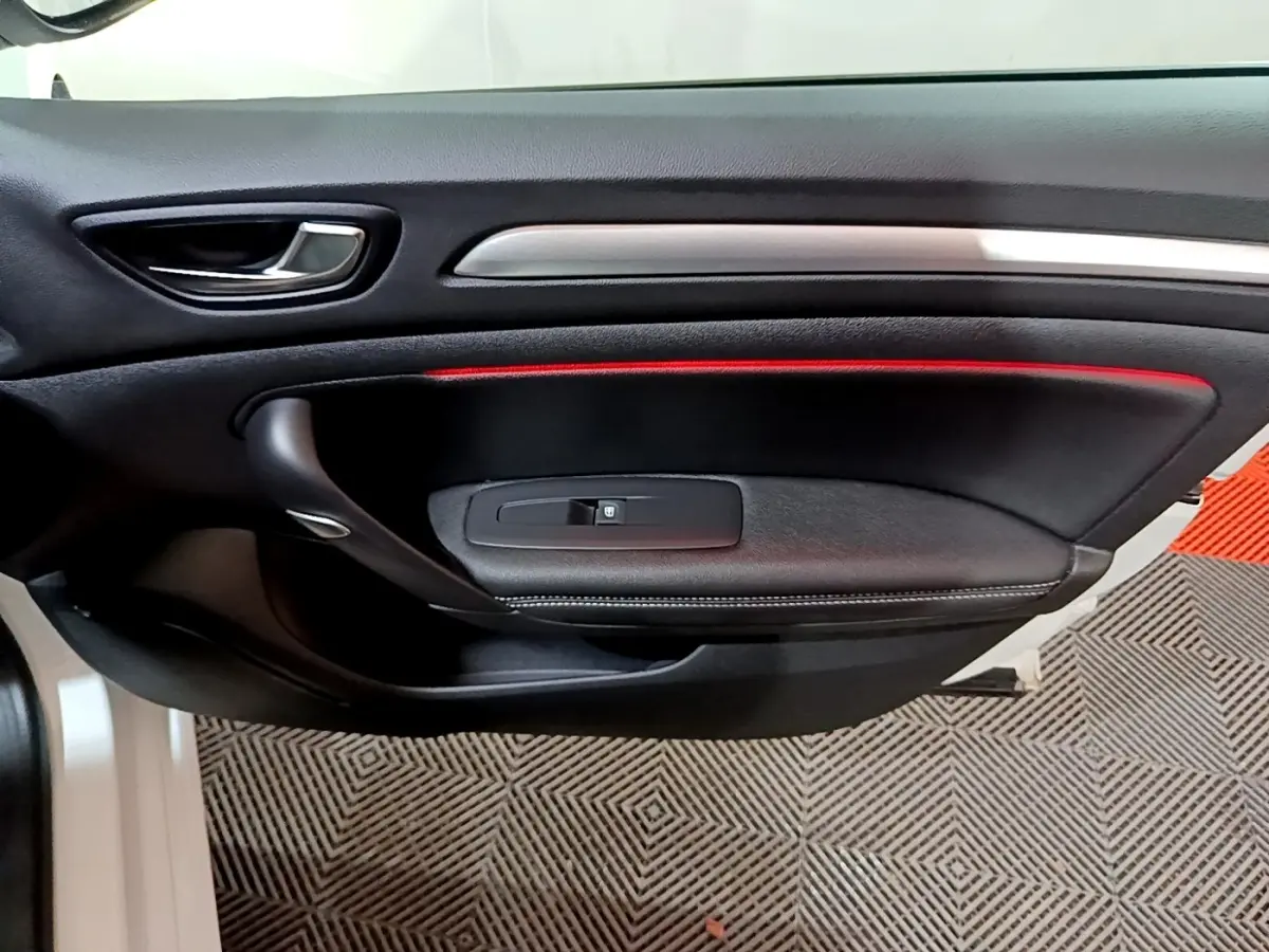 Vue rapprochée de la porte intérieure côté gauche noire avec bande lumineuse rouge de la Renault Mégane Techno 2023 blanche.