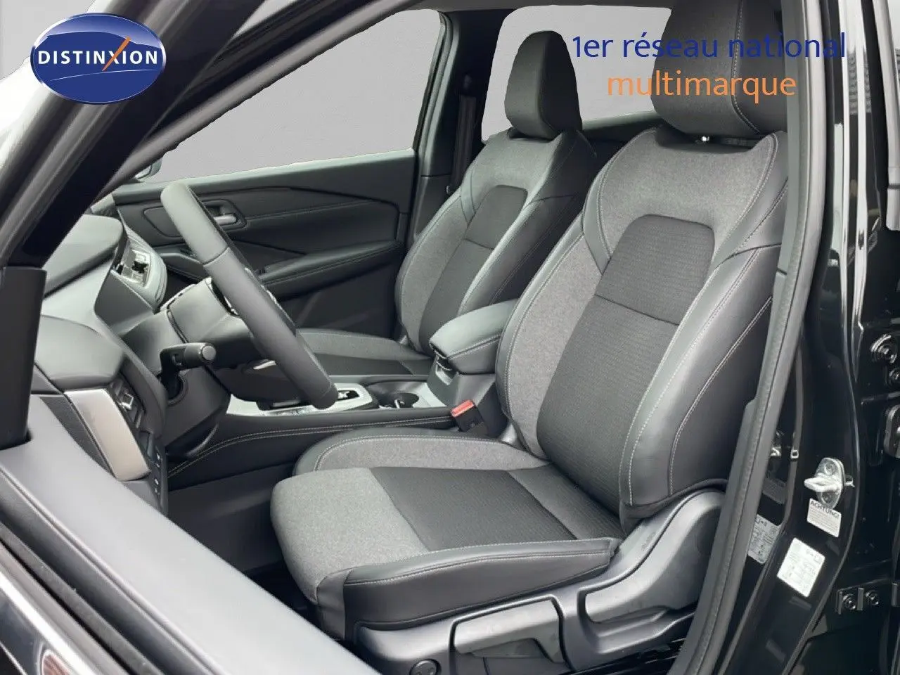 Vue intérieure côté conducteur du Nissan Qashqai 2025 noir perle métal, sièges tissu et cuir gris foncé.