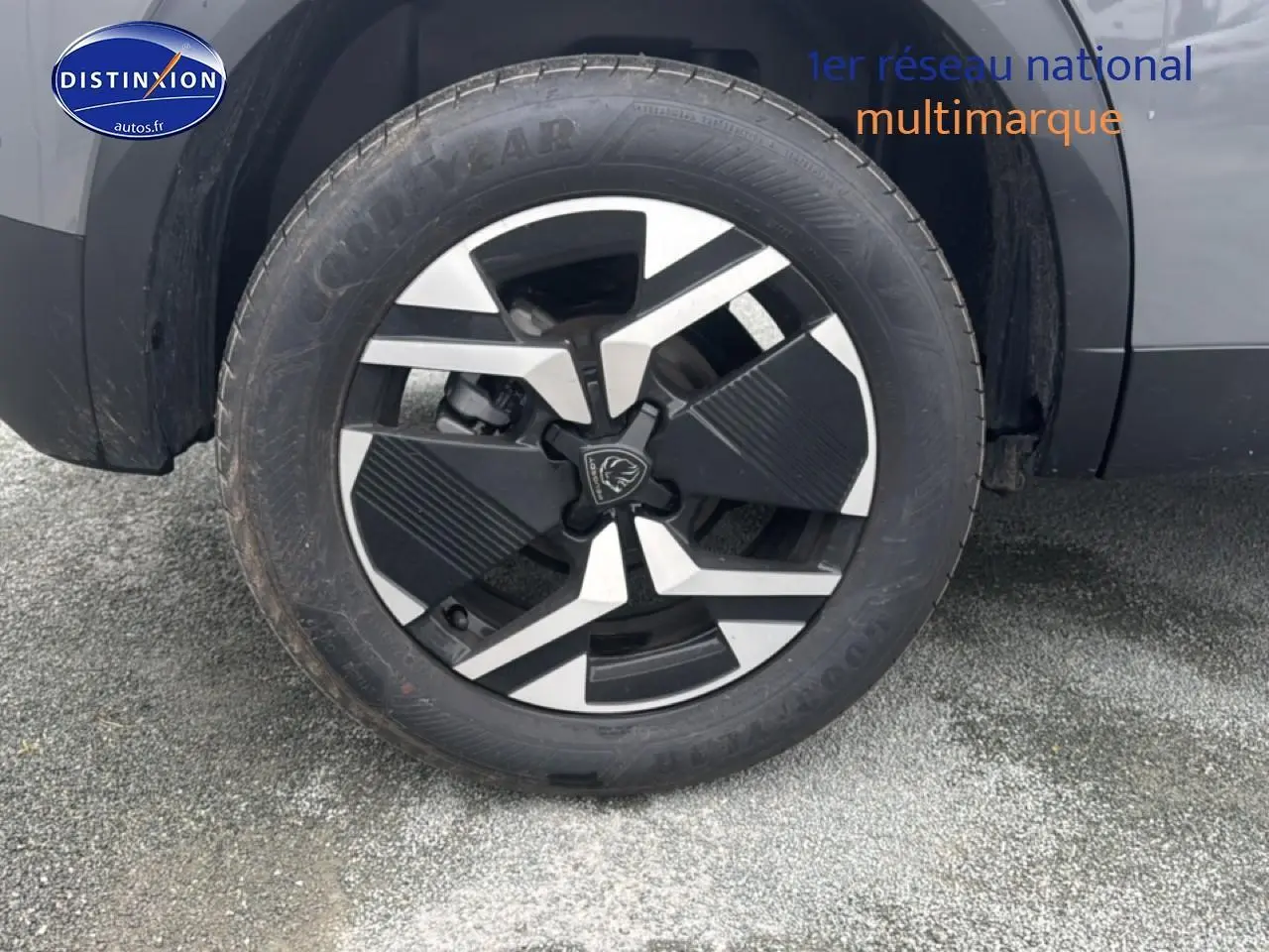 Gros plan sur la roue avant droite avec jante alu noire et argentée du Peugeot 2008 gris sellenium 2025.