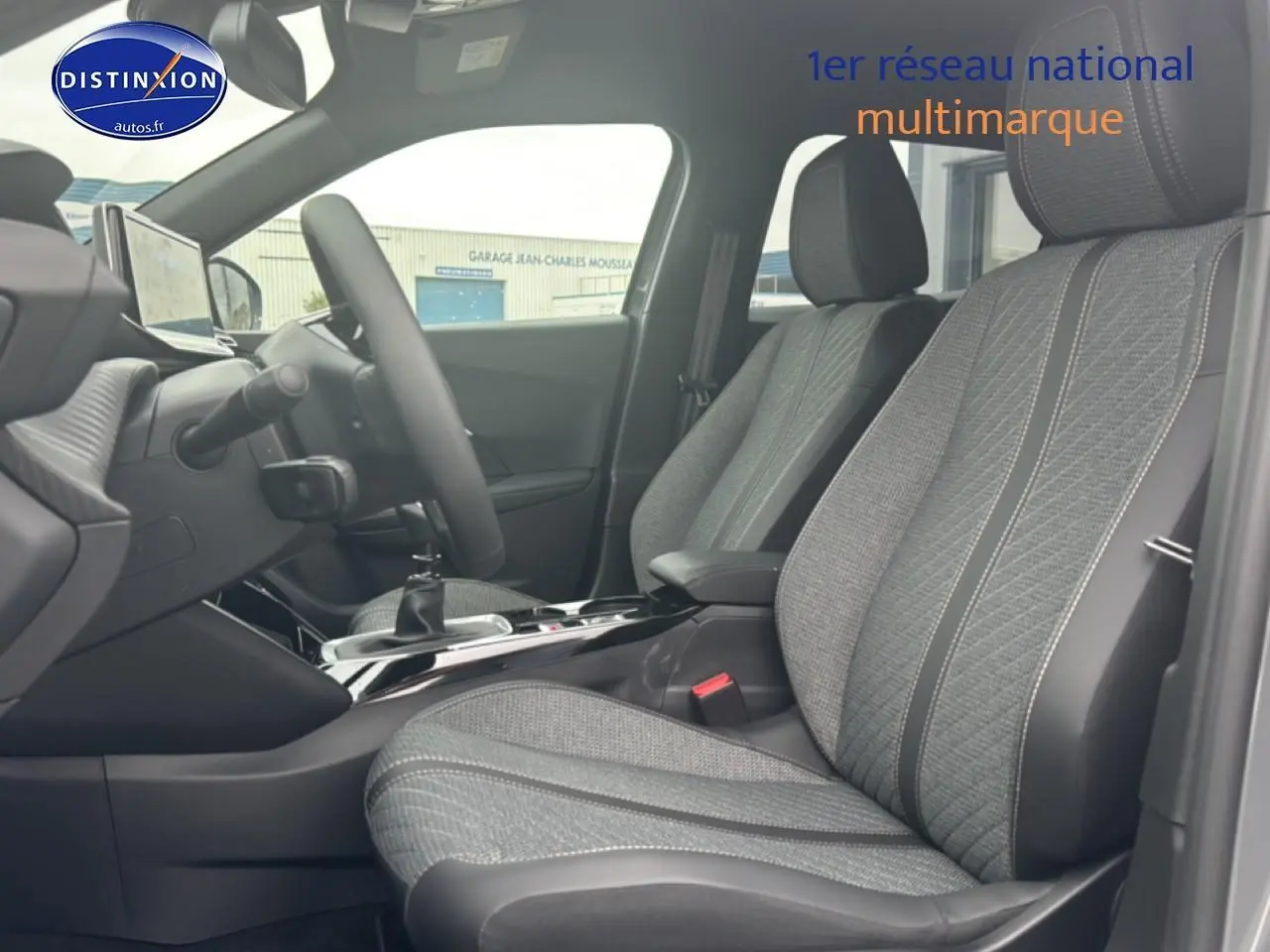 Vue intérieure côté gauche du Peugeot 2008 1.2 100 allure 2025, sièges tissu gris casual lomsa embossé avec volant multifonction.