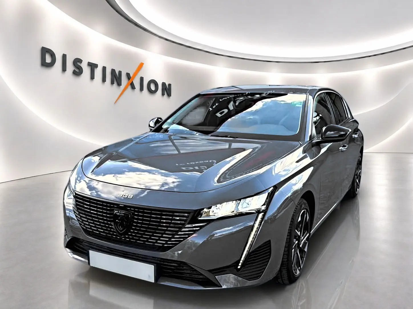 Vue 3/4 avant d'une Peugeot 308 gris selenium avec calandre noire et feux LED verticaux, en showroom lumineux.