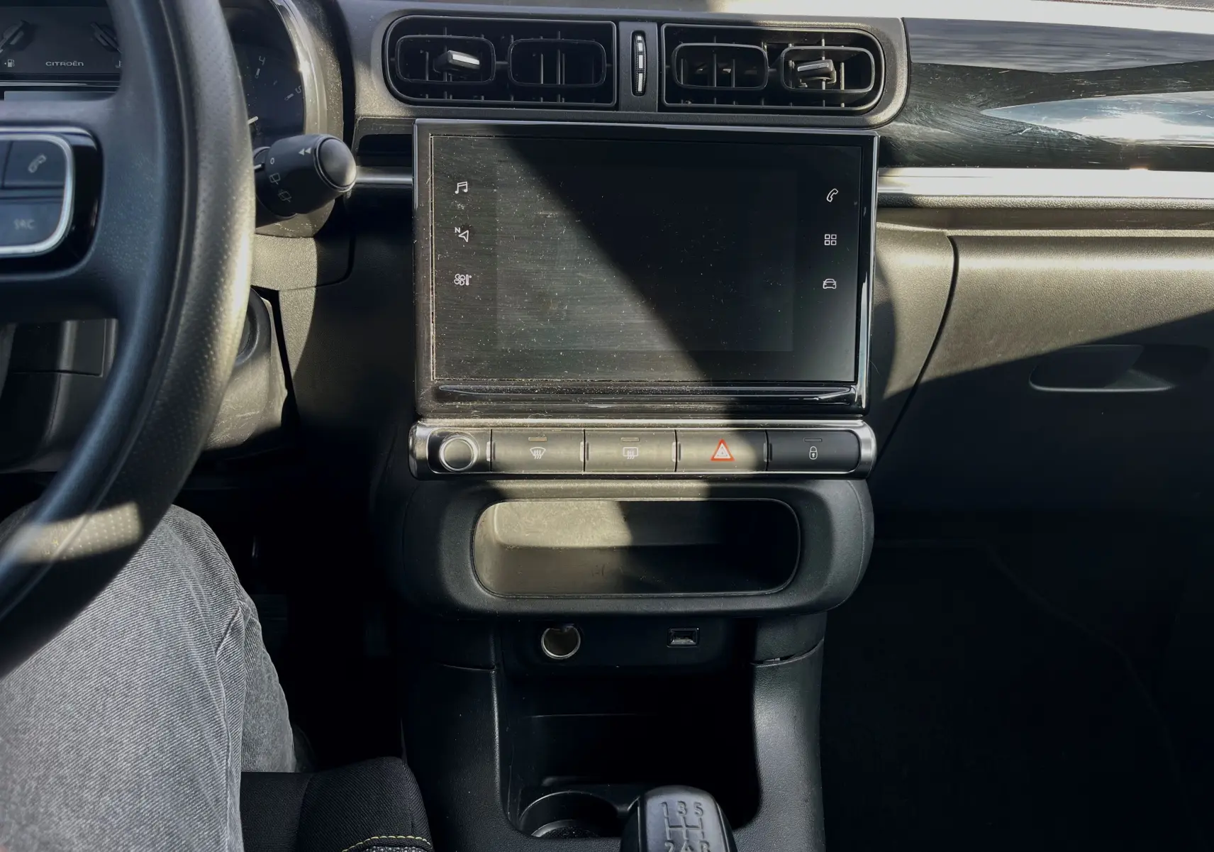 Vue intérieure centrée sur la console centrale et l'écran tactile de la Citroën C3 blanche de 2019 avec boîte manuelle.