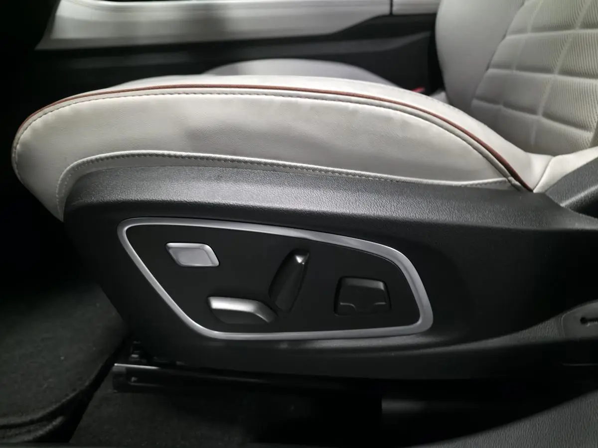 Gros plan sur les commandes électriques du siège avant gris sable clair perforé du Renault Espace 2025.