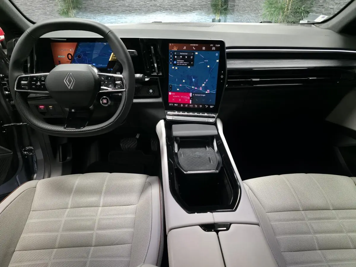 Intérieur du Renault Espace 2025, vue frontale du tableau de bord avec écran tactile vertical et sellerie textile gris sable clair.