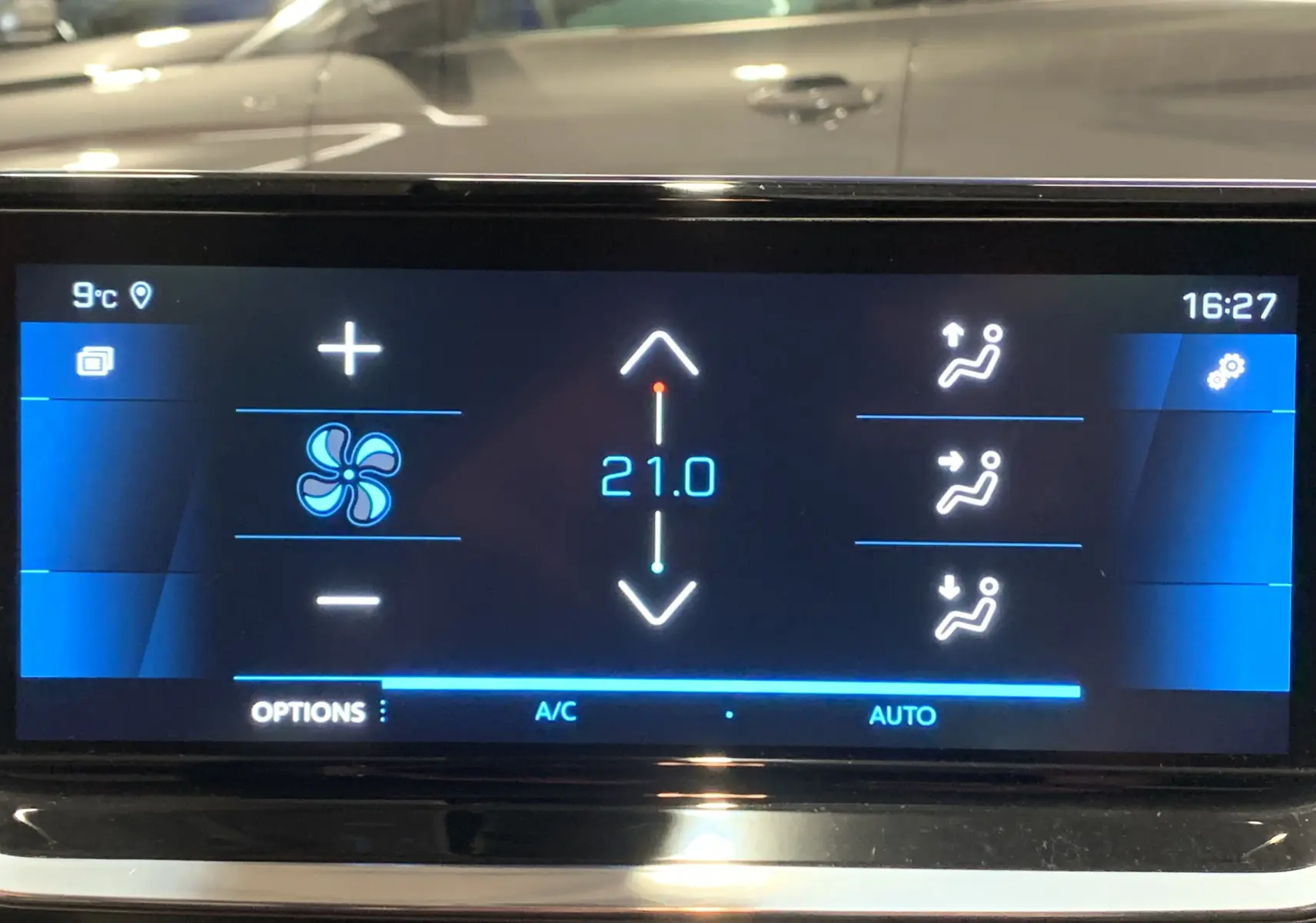 Écran tactile intérieur de la Peugeot 208 gris, affichant la climatisation réglée à 21°C en mode automatique.