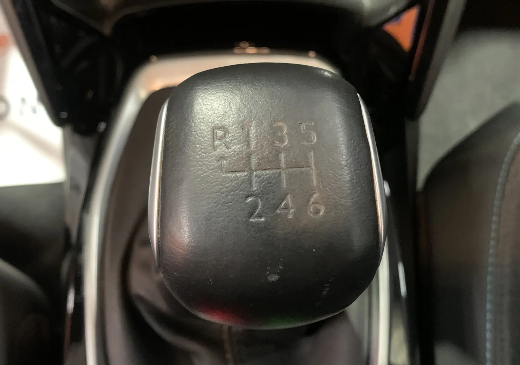 Gros plan sur le levier de vitesses manuel noir de la Peugeot 208 PureTech 100 Allure Business, montrant le schéma des 6 rapports.