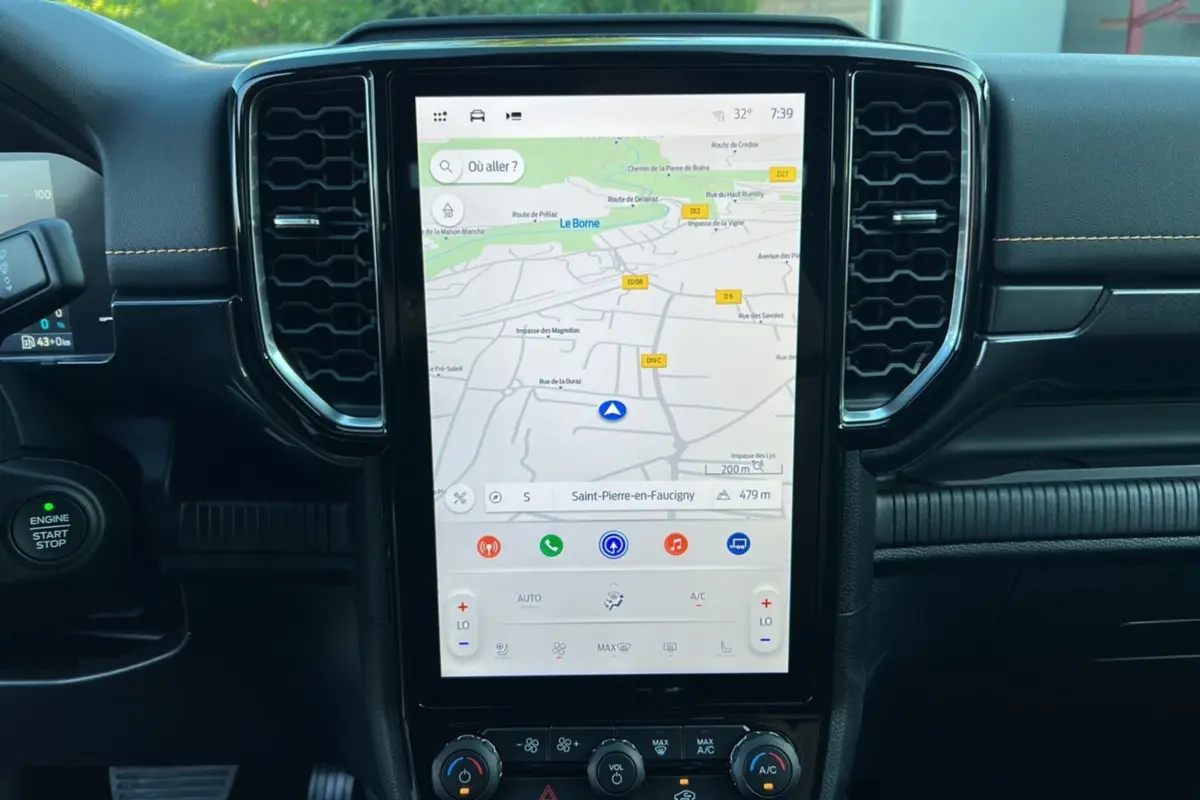 Vue rapprochée de la console centrale du Ford Ranger PHEV 2025, écran tactile GPS vertical et tableau de bord noir.