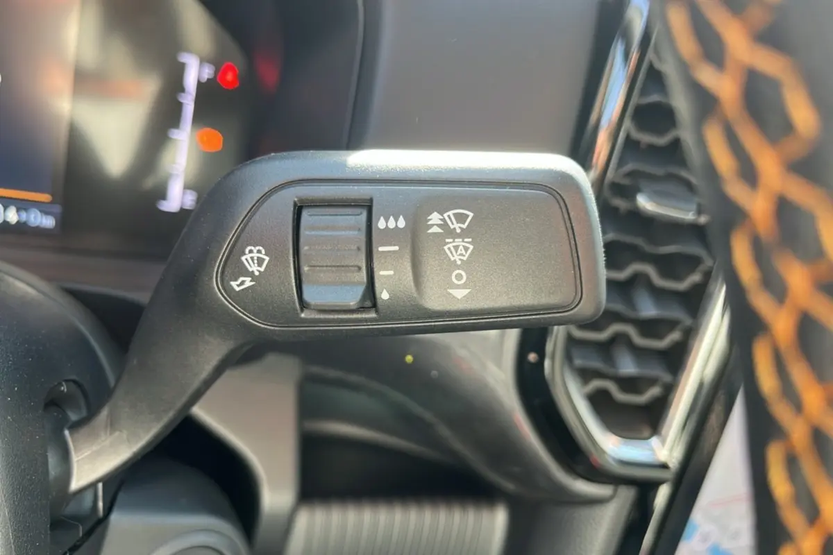 Gros plan sur la commande des essuie-glaces du Ford Ranger PHEV 281 Wildtrak gris carbone, intérieur noir avec surpiqûres orange.