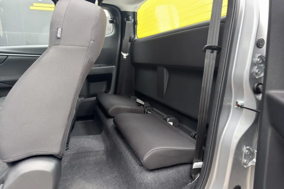 Vue intérieure côté droit du pick-up Isuzu D-MAX 2026 Mercury silver avec strapontins arrière rabattus.