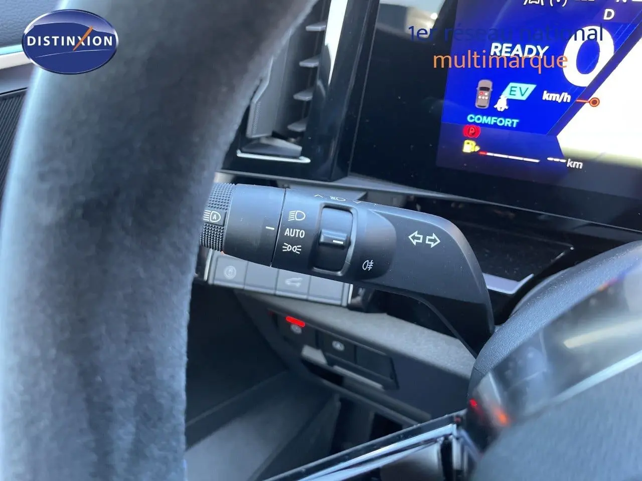 Détail intérieur du volant et commande des feux du Renault Austral E-Tech noir étoile métal, avec affichage numérique au tableau de bord.
