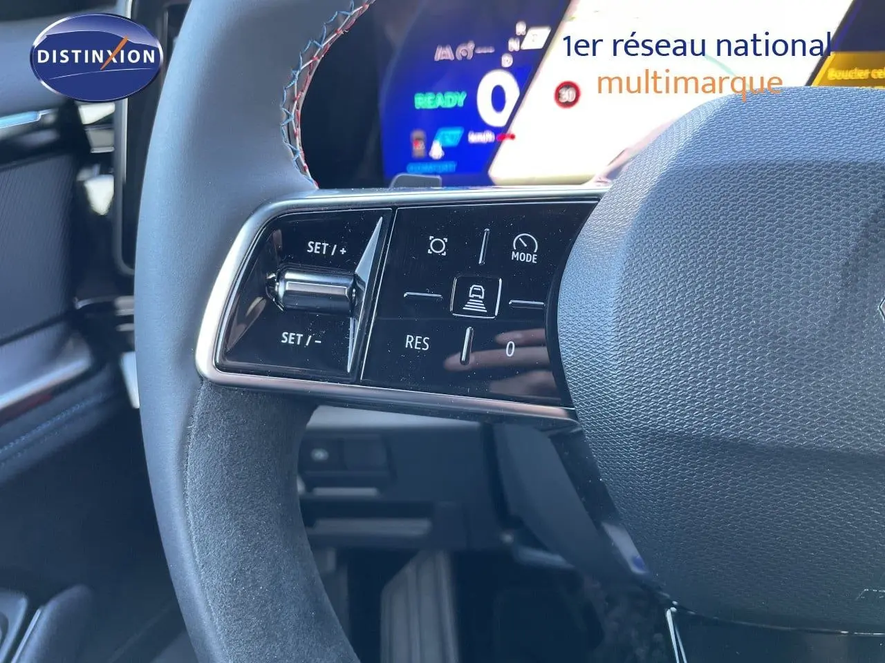Gros plan sur la partie gauche du volant du Renault Austral noir étoile métal, avec commandes intégrées et tableau de bord numérique en arrière-plan.