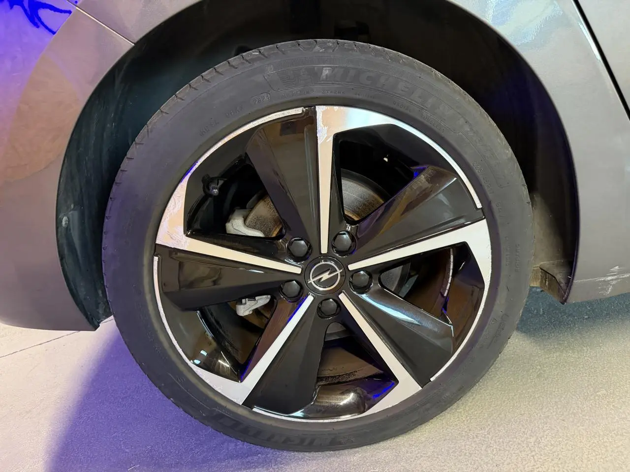 Gros plan sur la jante alliage 17 pouces diamantée noire et argentée de l'Opel Astra gris foncé 2024.