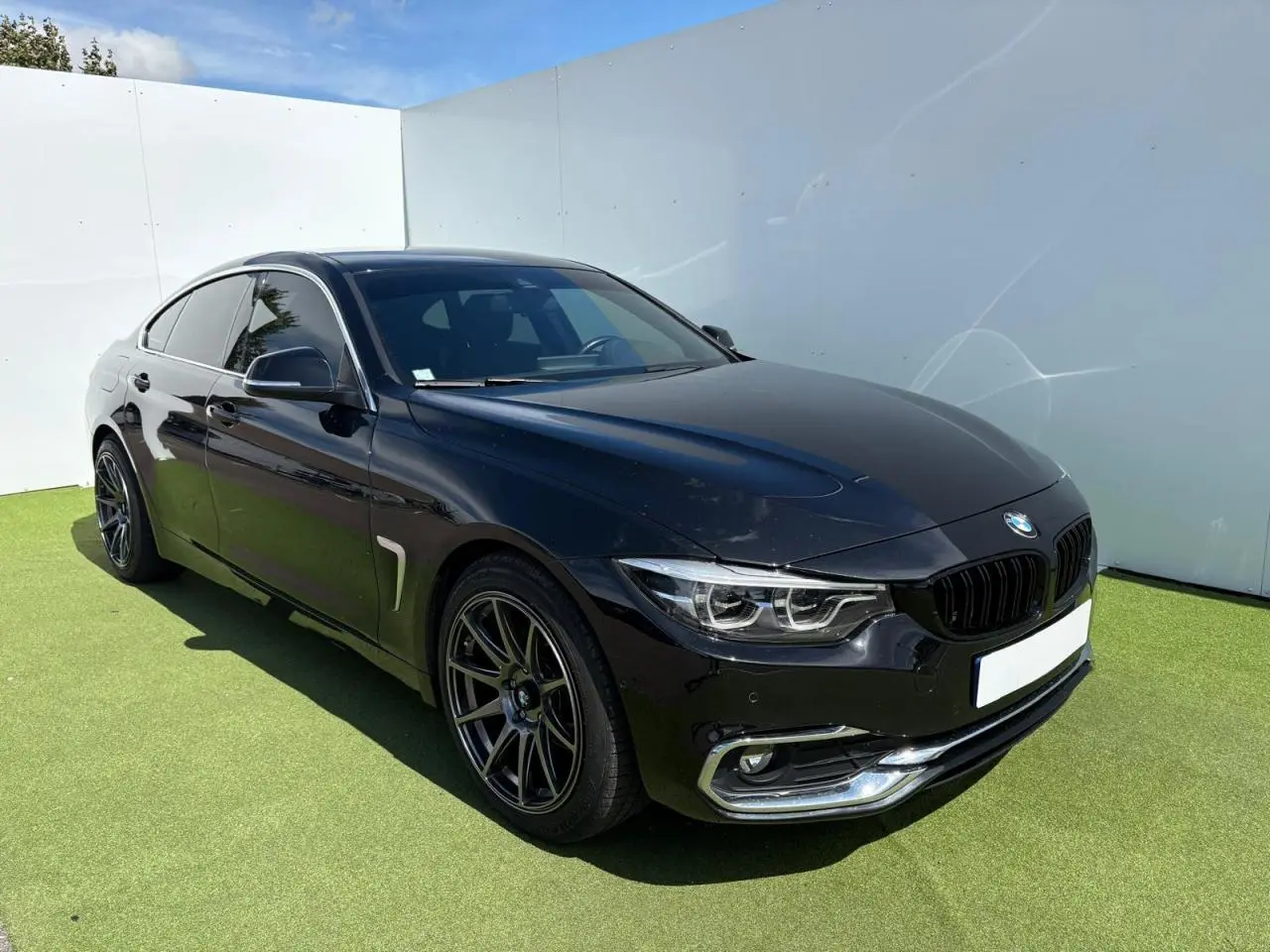 BMW Série 4 Gran Coupé noir saphir vue 3/4 avant droit avec jantes alliage et phares LED Full LED
