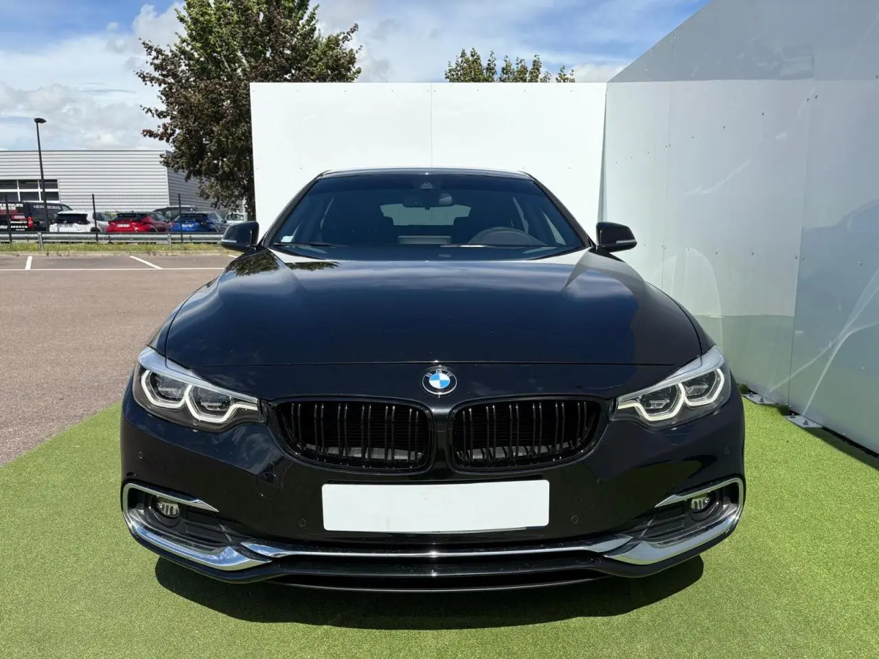 BMW Série 4 Gran Coupé noir saphir vue de face, mettant en valeur ses phares Full LED et calandre noire brillante.