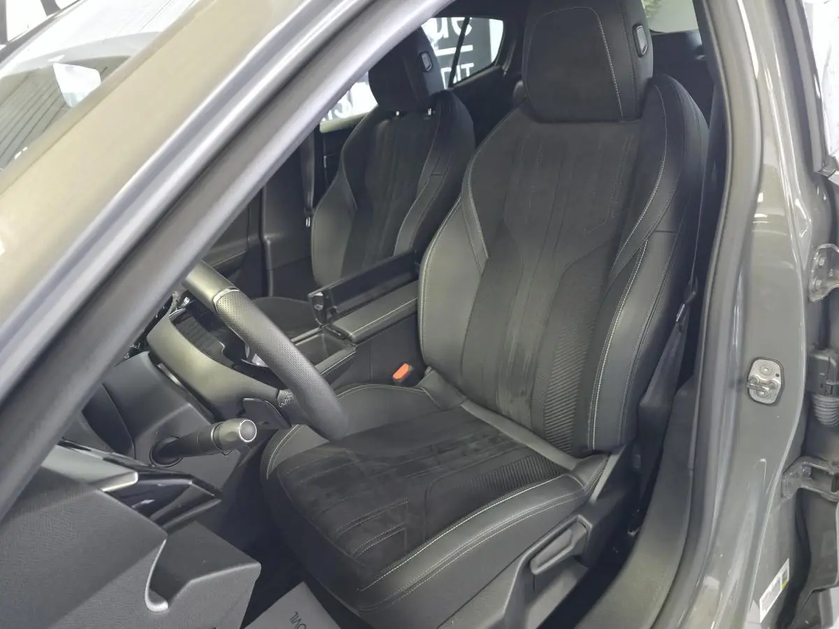 Siège avant conducteur en tri-matière noir avec surpiqûres blanches sur Peugeot 408 gris, vue intérieure côté gauche.