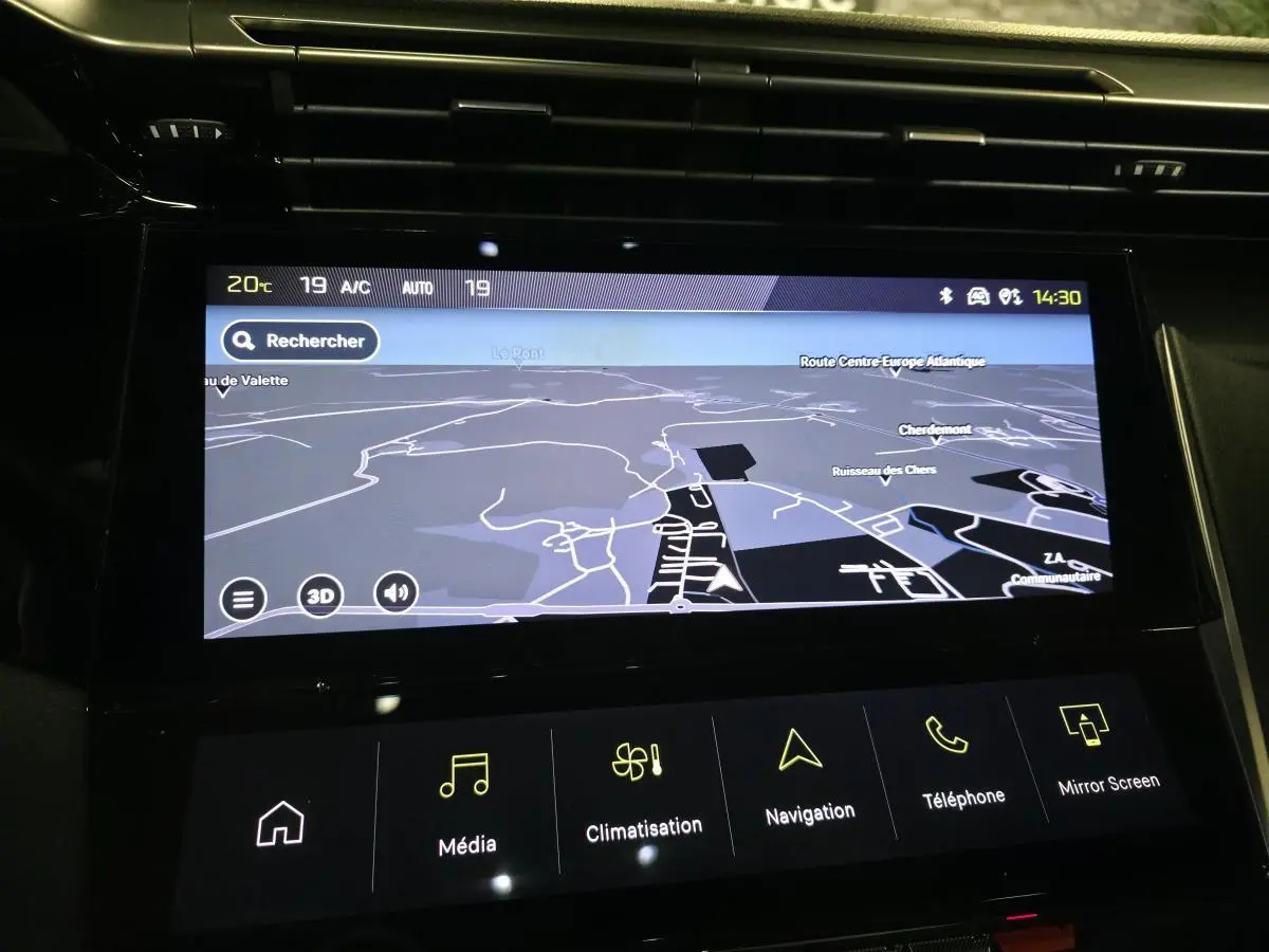 Écran tactile central de navigation allumé dans l'habitacle noir du Peugeot 408 gris 2024, vue rapprochée.