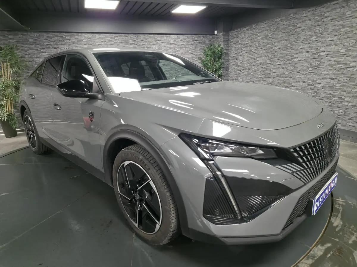 PEUGEOT 408 gris Selenium en 3/4 avant droit, avec calandre distinctive et jantes alliage noires diamantées.