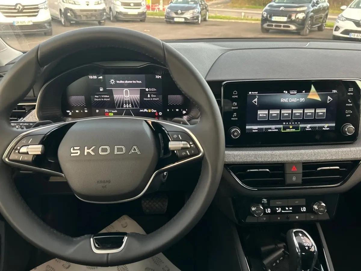 Vue intérieure du tableau de bord et volant Skoda Kamiq gris clair 2025 avec écran tactile et combiné numérique.