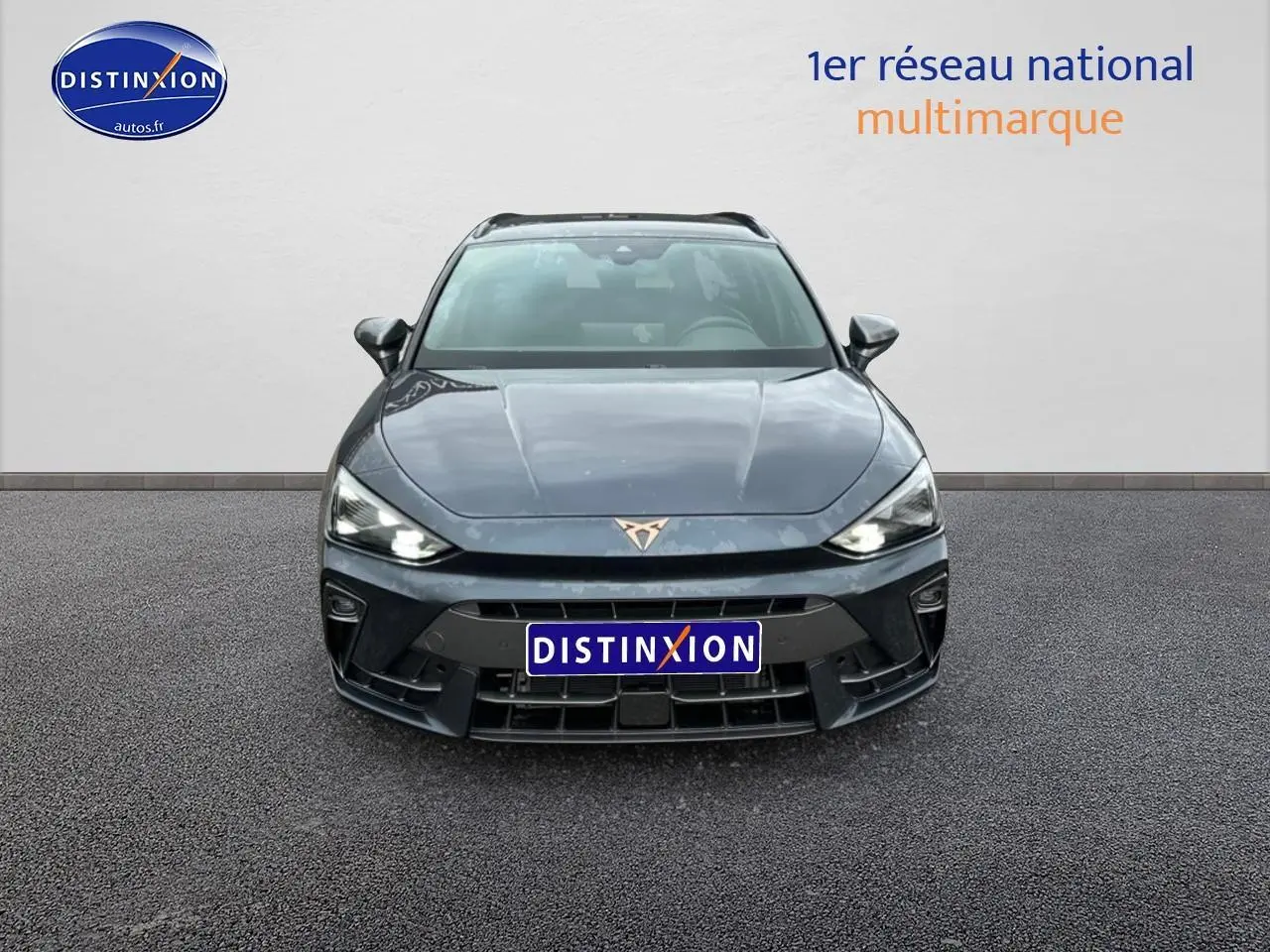 Vue frontale d'une CUPRA LEON ST 1.5 etsi hybrid 2025 en gris magnétique avec phares LED allumés.