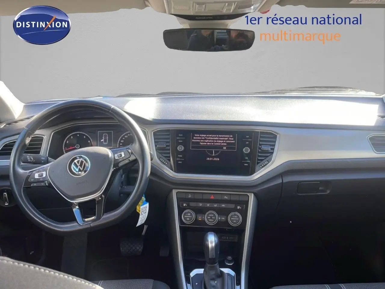 Vue intérieure avant du Volkswagen T-Roc bleu Ravenna Metal 2021, mettant en valeur le tableau de bord et le volant multifonction.