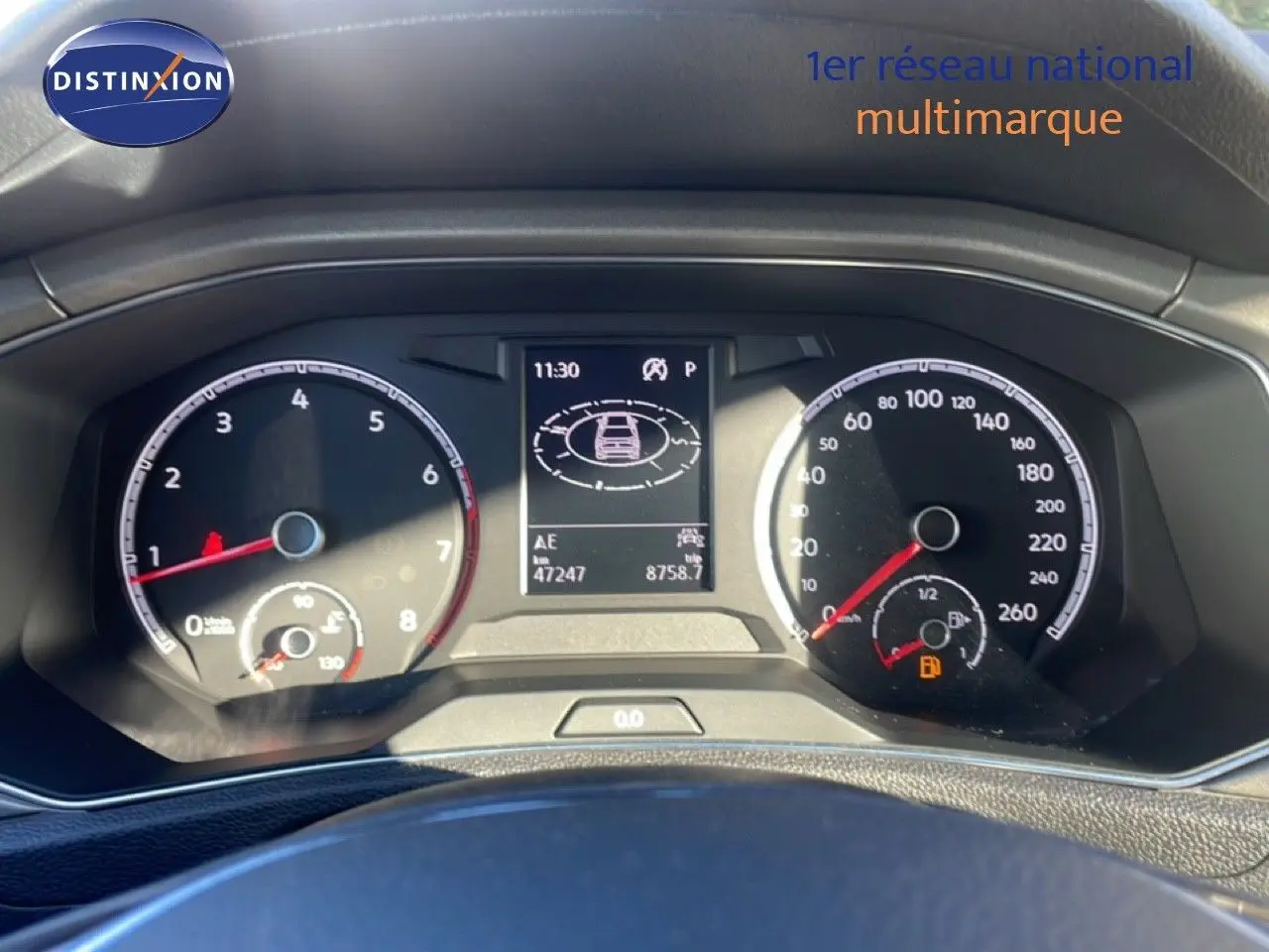 Vue rapprochée du tableau de bord du Volkswagen T-Roc 1.5 TSI bleu Ravenna, affichant compteurs et écran central numérique.