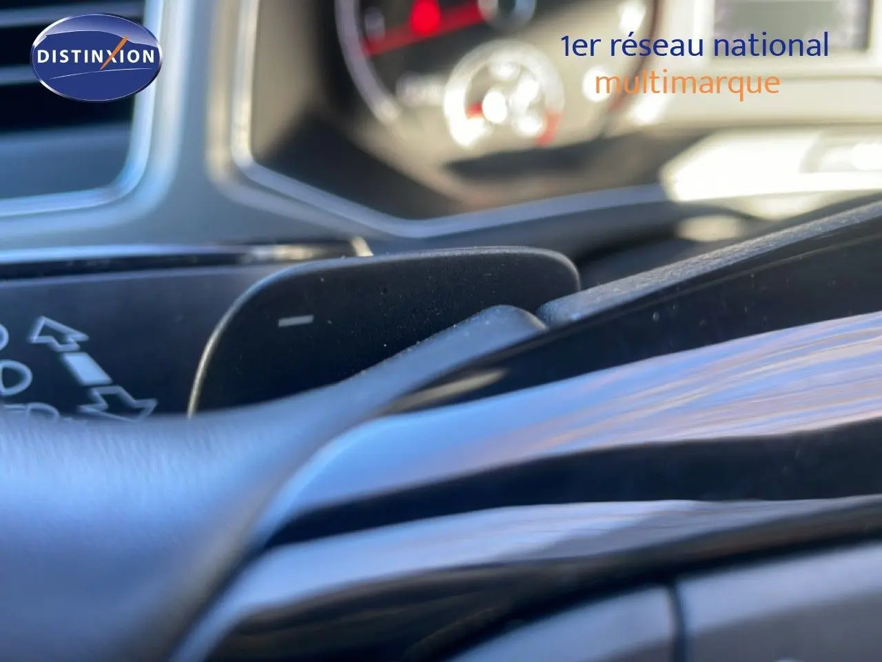 Gros plan sur la palette de changement de vitesse au volant du Volkswagen T-Roc bleu Ravenna, intérieur noir.