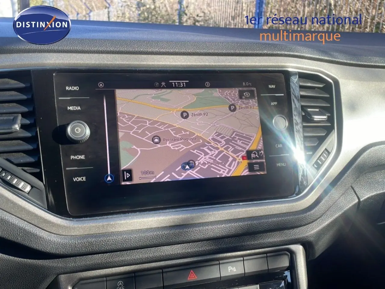 Écran tactile central avec navigation GPS dans l’habitacle d’un Volkswagen T-Roc bleu Ravenna, vue de face.