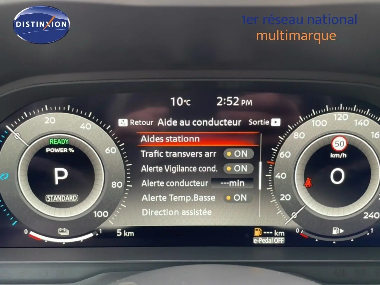 Tableau de bord numérique du Nissan Qashqai gris, affichant l'aide au conducteur et la vitesse à 0 km/h.