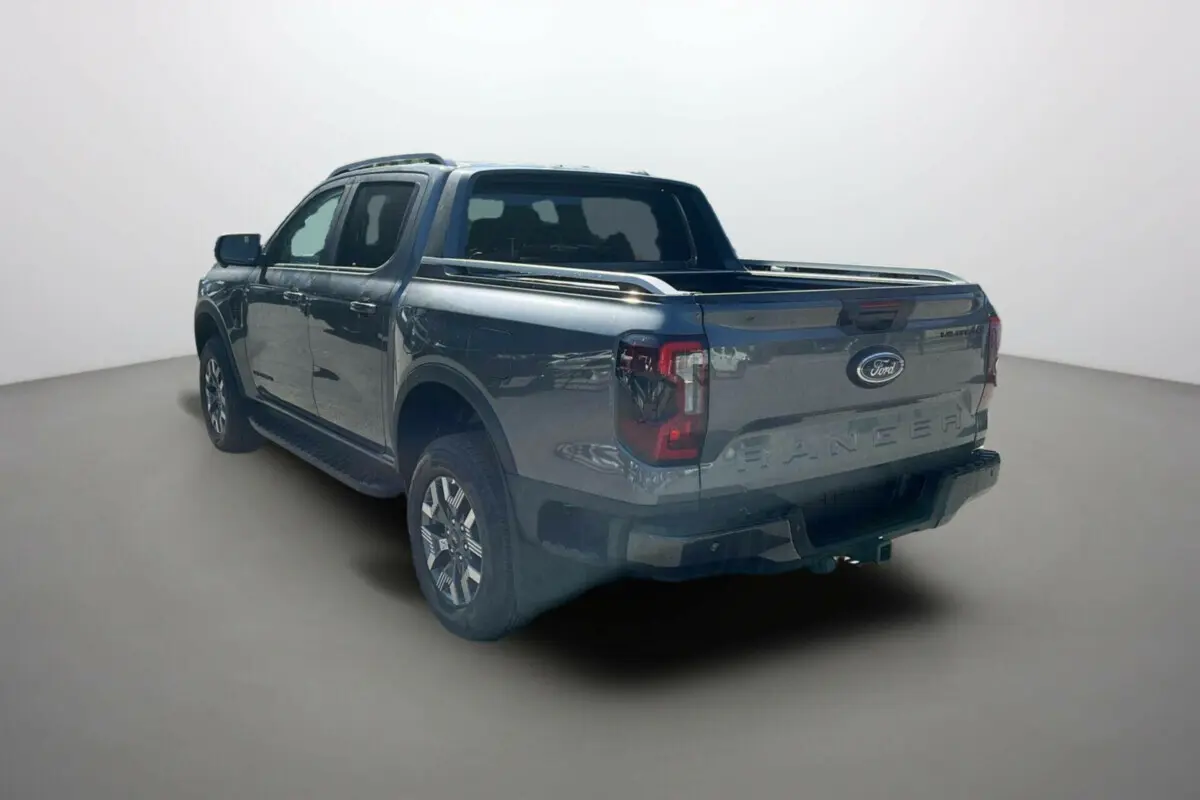 Ford Ranger PHEV gris carbone vu en 3/4 arrière droit, avec benne ouverte et jantes alu 18 pouces.