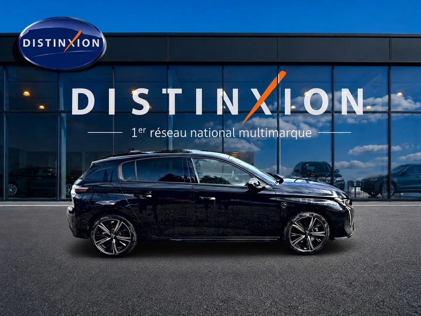 Profil côté gauche d'une Peugeot 308 noire 2025 garée devant une vitrine avec logo Distinxion.