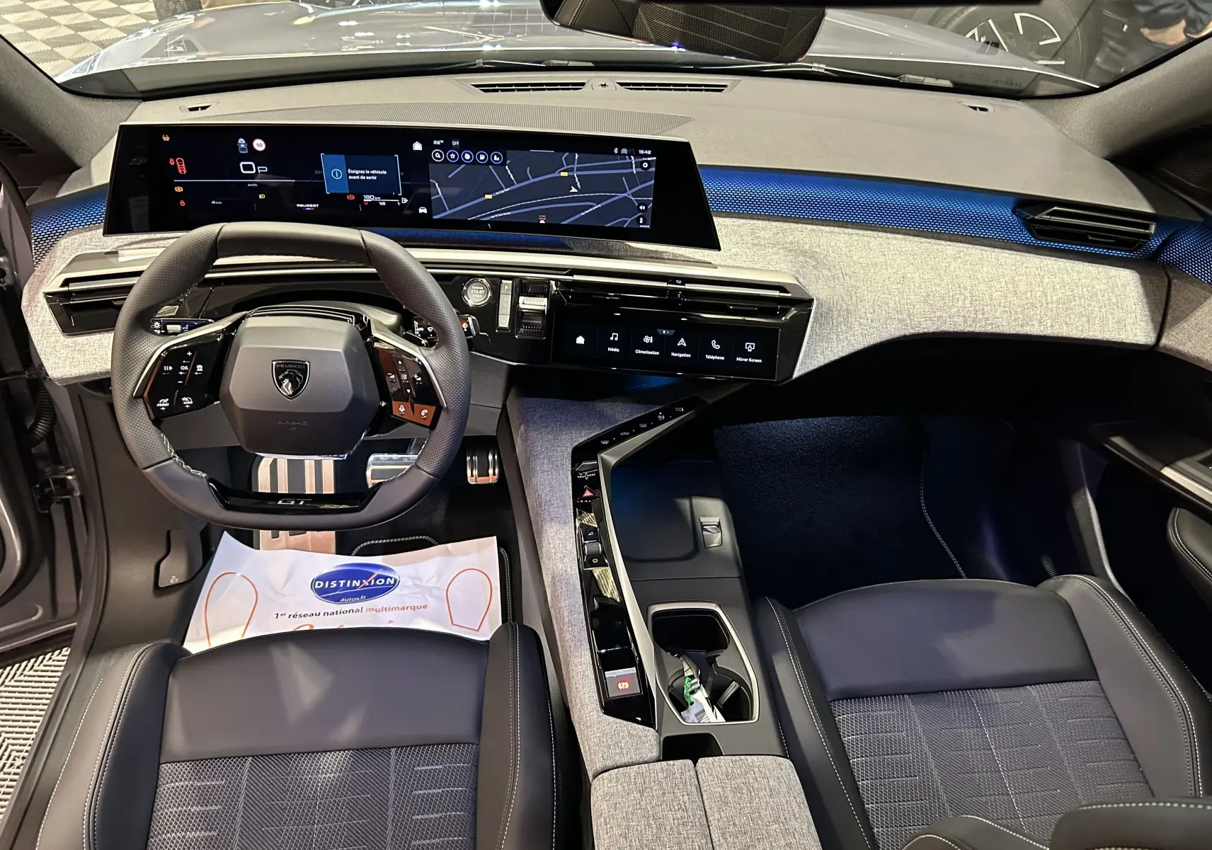 Intérieur moderne du Peugeot 5008 III GT Hybrid 145, vue de dessus sur le tableau de bord et le volant compact.