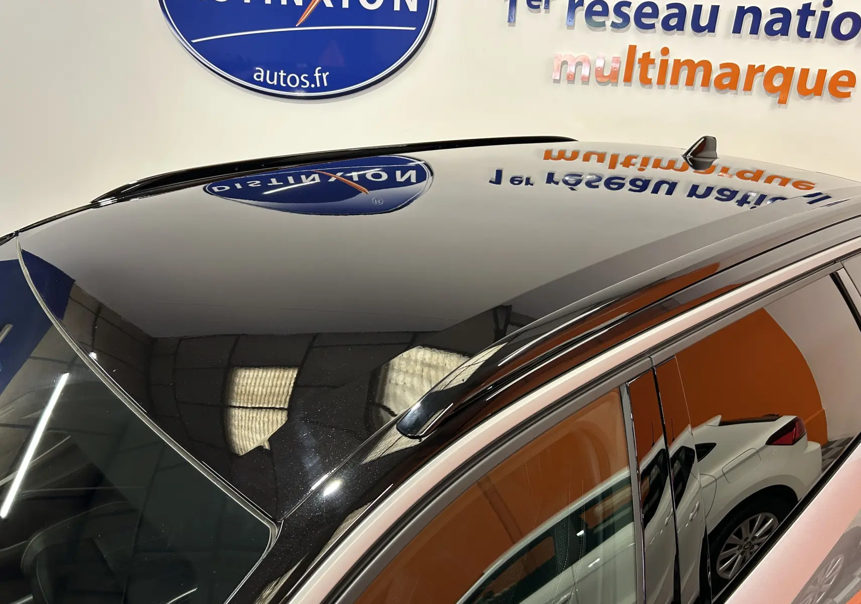 Toit panoramique noir brillant du Peugeot 5008 gris Artense, vu de dessus côté gauche avec reflet intérieur showroom.