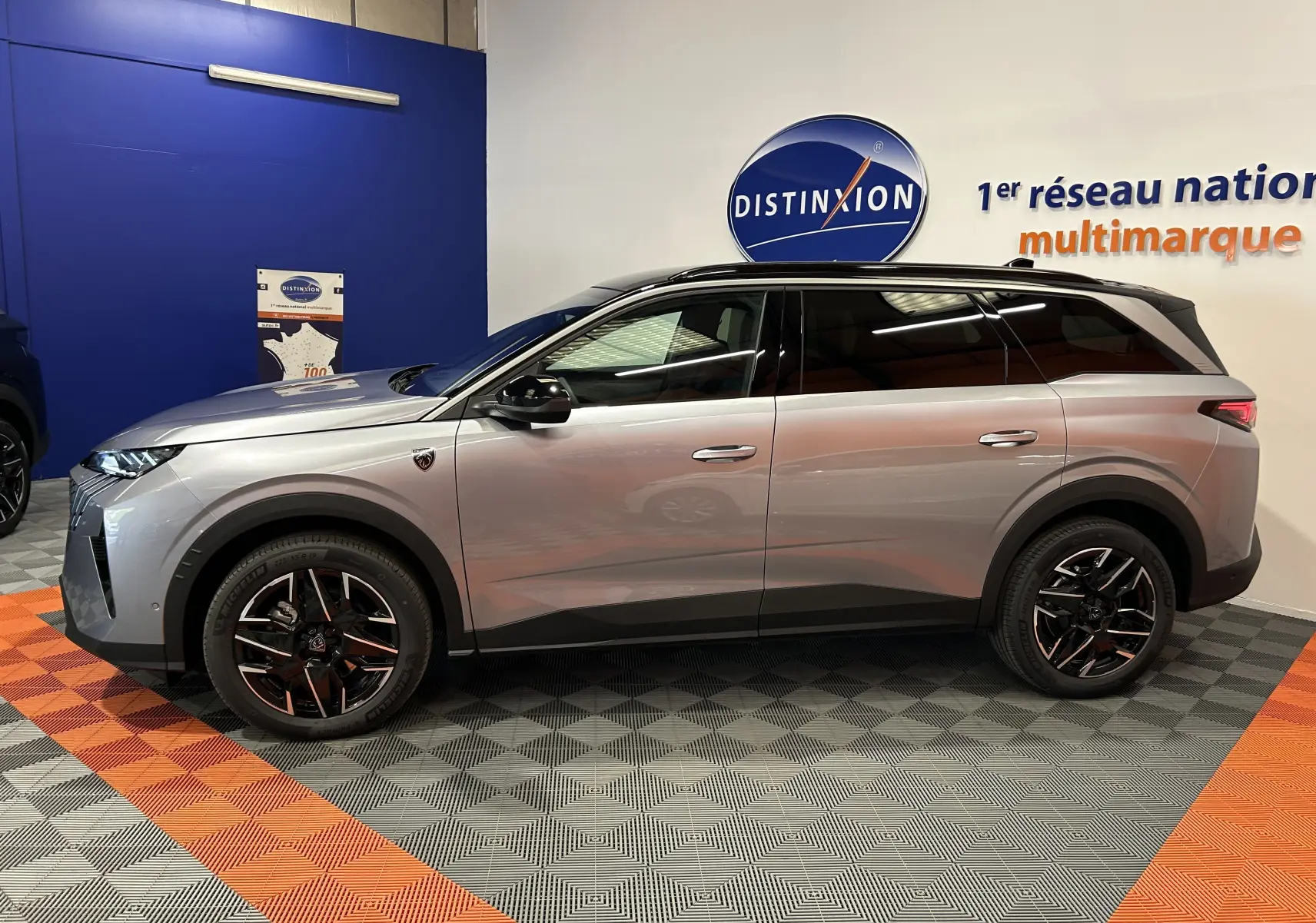 Peugeot 5008 III GT Hybrid gris Artense vu de profil côté gauche, avec jantes noires et toit noir biton.