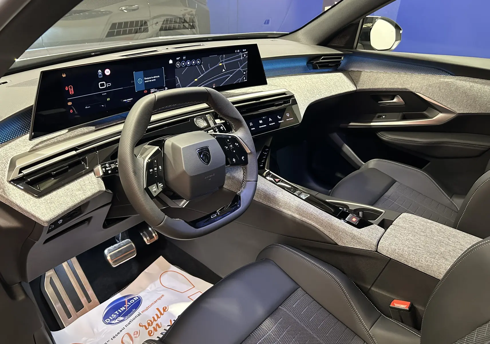 Intérieur avant droit du Peugeot 5008 III GT Hybrid 145 avec tableau de bord numérique et sellerie noire et grise.