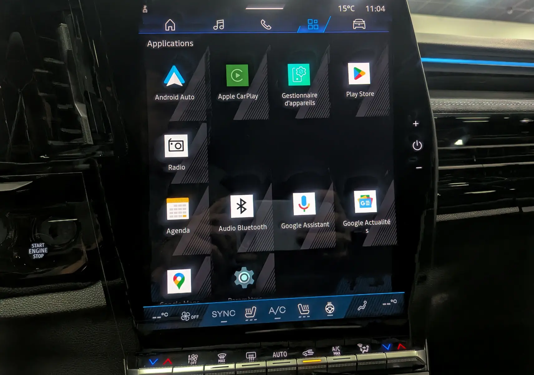 Écran tactile central du Renault Austral 2025 full hybride, affichant les applications connectées dans l'habitacle noir.