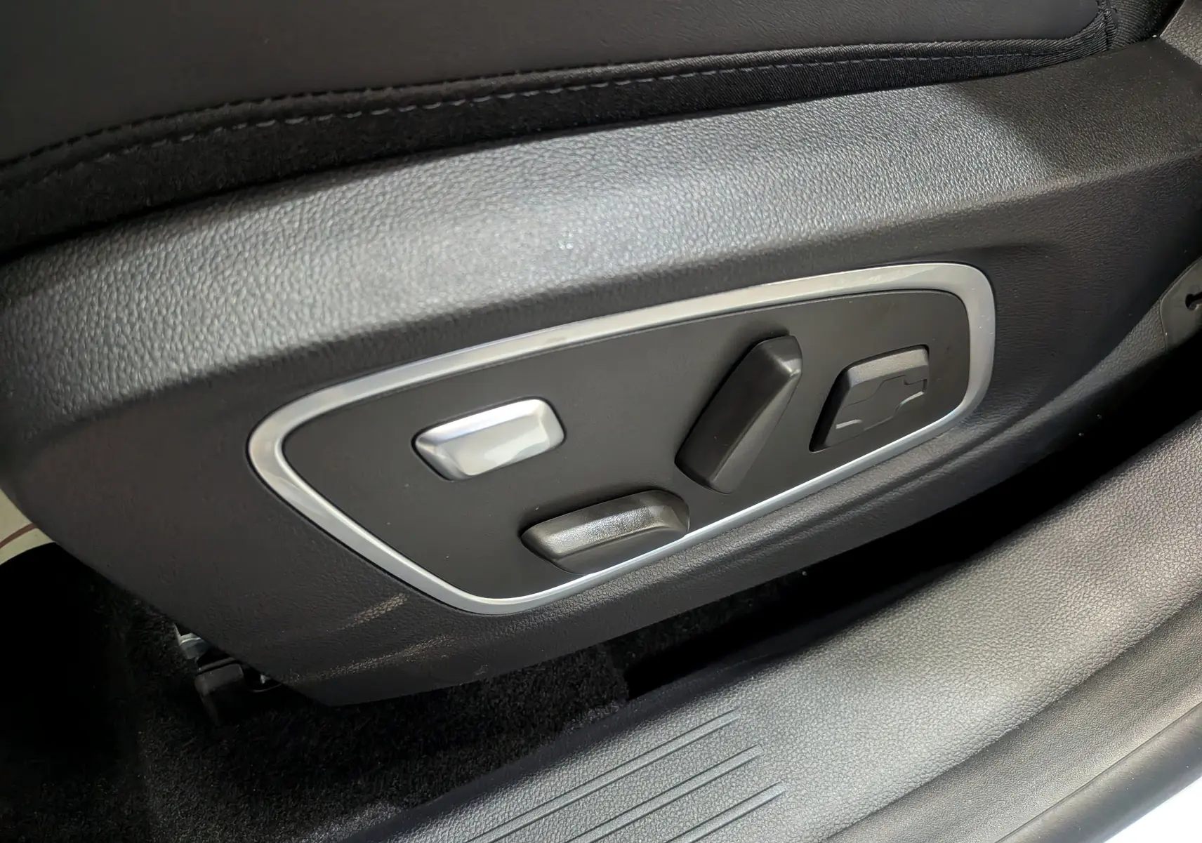 Commandes de réglage électrique des sièges en gros plan dans l'habitacle du Renault Austral blanc nacré satin 2025.