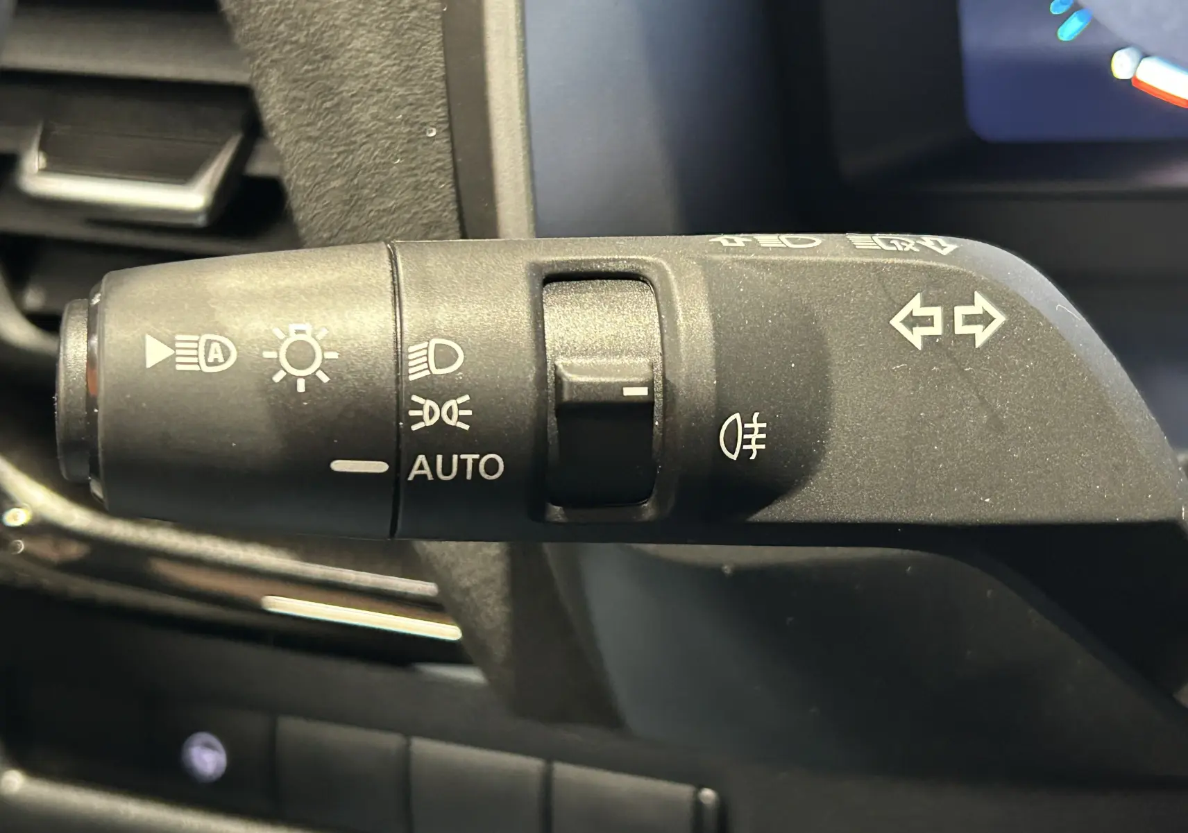 Gros plan sur la commande des feux et clignotants du Nissan Qashqai 2025, intérieur noir.