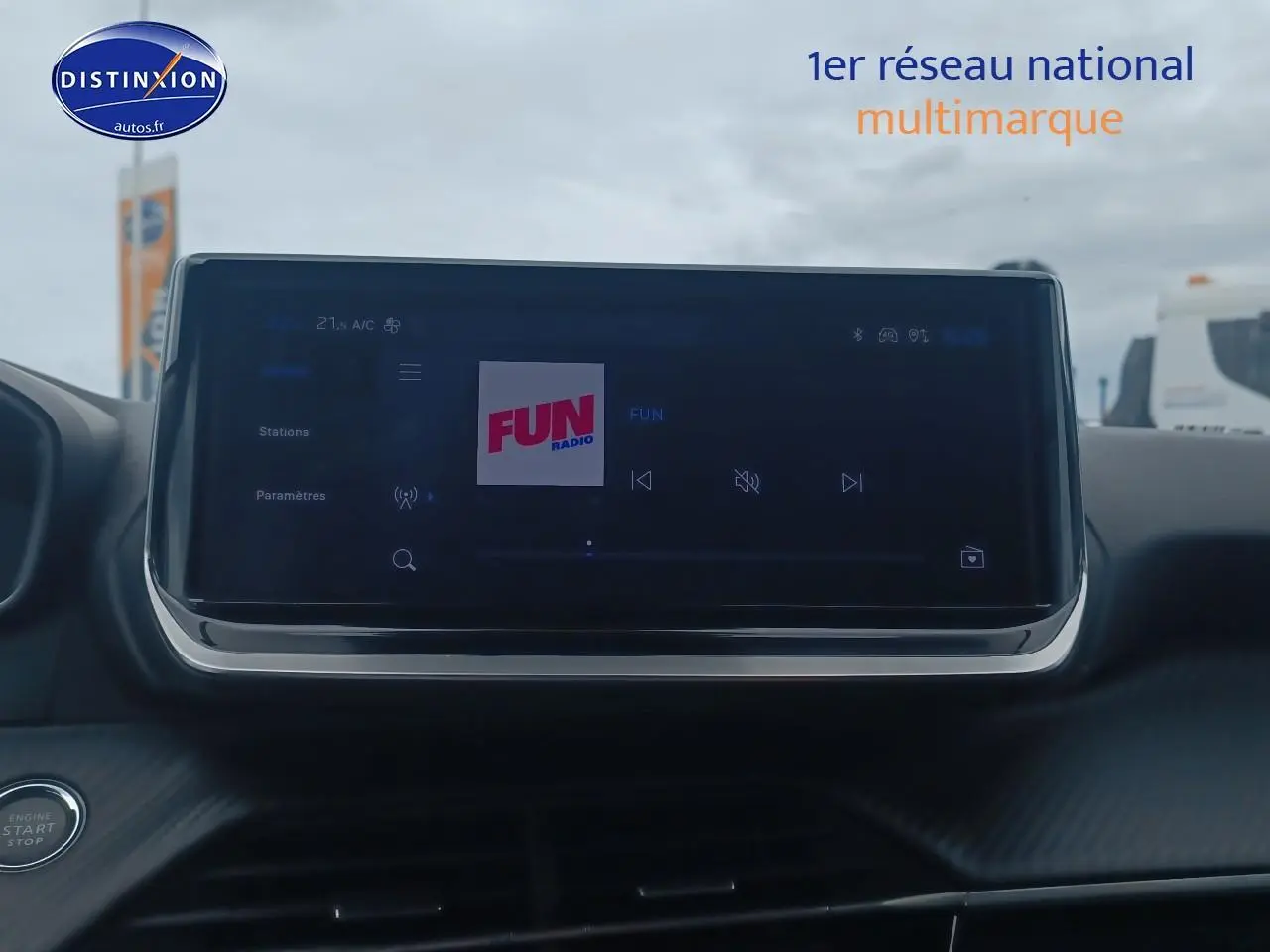 Écran tactile central allumé sur radio FUN dans l’habitacle d’une Peugeot 2008 rouge Elixir, vue de face.