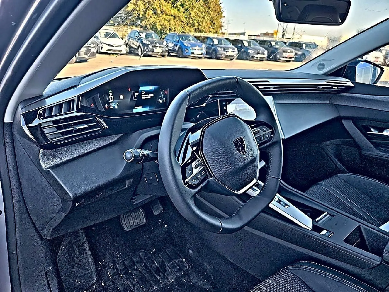 Vue intérieure côté conducteur du Peugeot 308 SW 2025, volant multifonction et tableau de bord numérique visibles.
