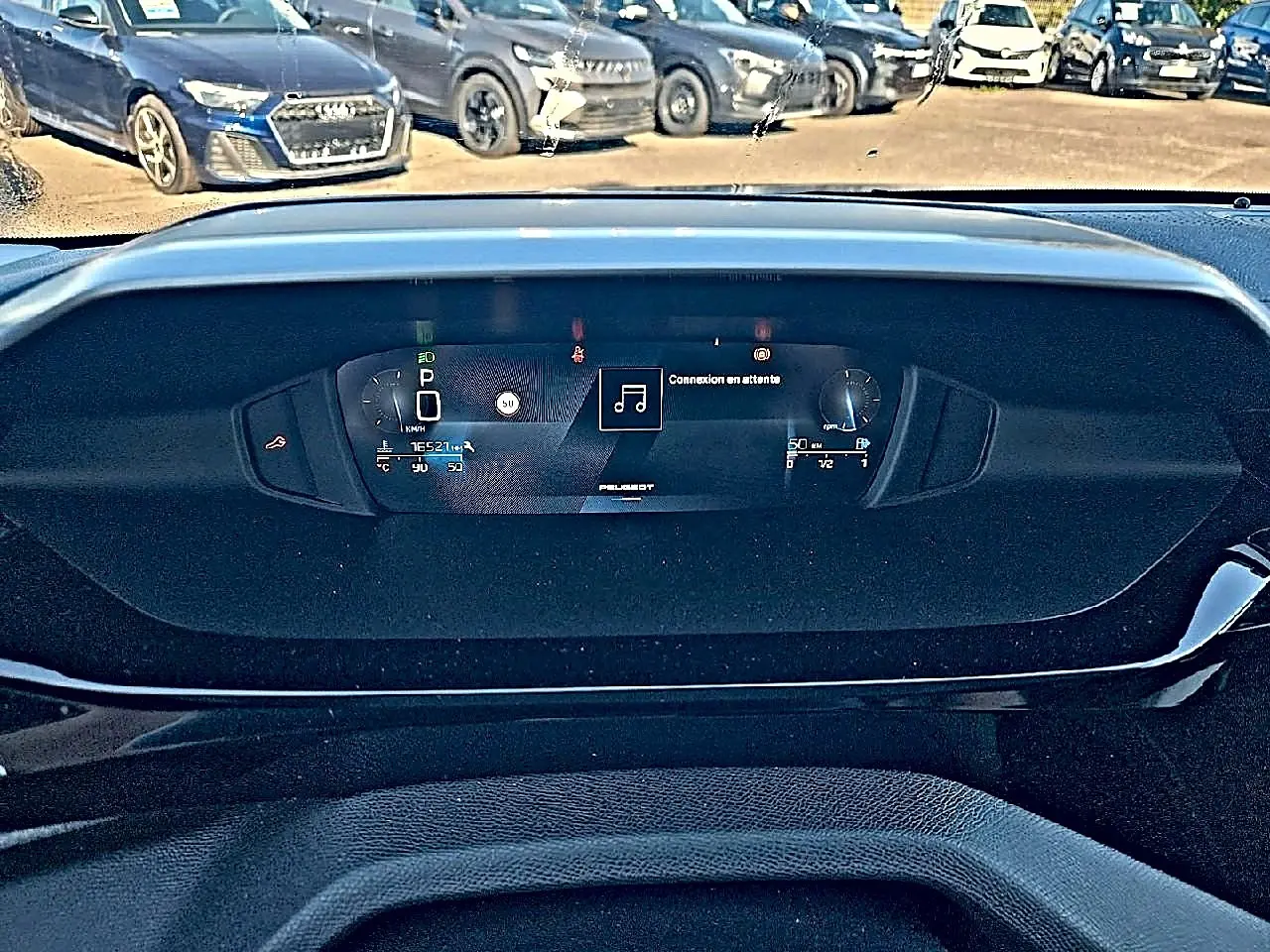 Tableau de bord numérique du Peugeot 308 SW 2025 affichant la vitesse et la musique, vue frontale intérieure.