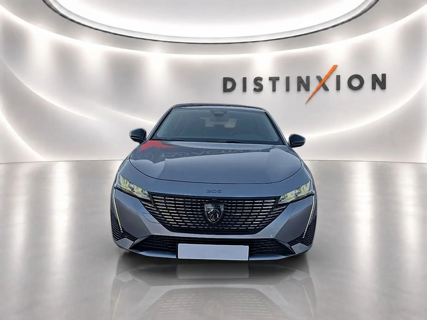 Peugeot 308 SW 2025 gris artense vue de face, avec calandre large et phares LED fins dans un studio lumineux.