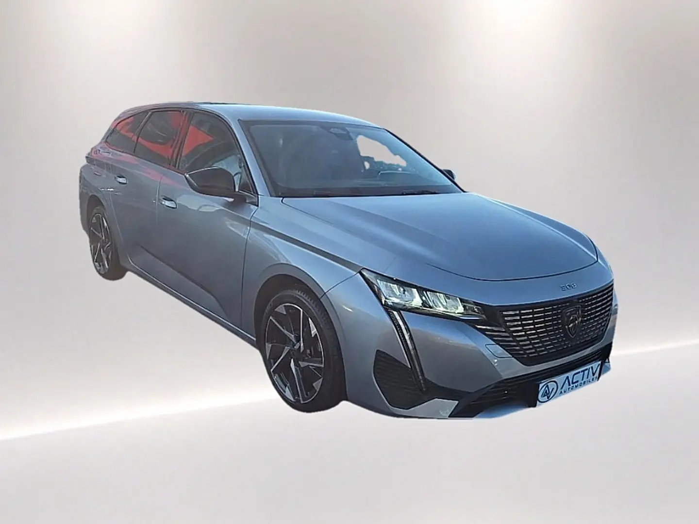 Peugeot 308 SW gris Artense vue 3/4 avant droit avec calandre noire et jantes alliage distinctives.