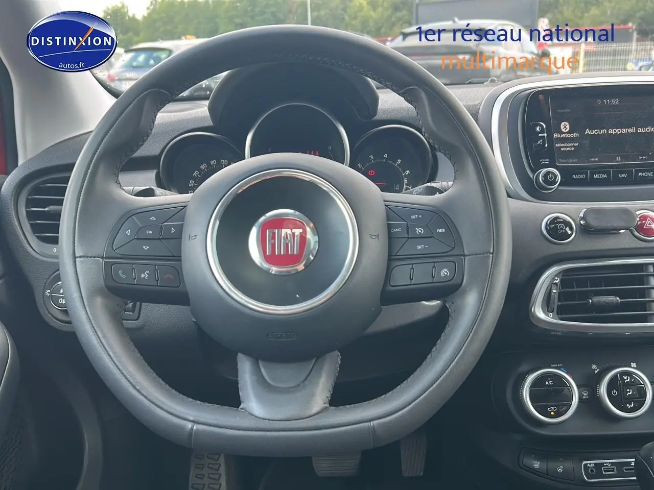 Vue centrée sur le volant cuir multifonction FIAT 500X 2016 avec tableau de bord et écran tactile visible.