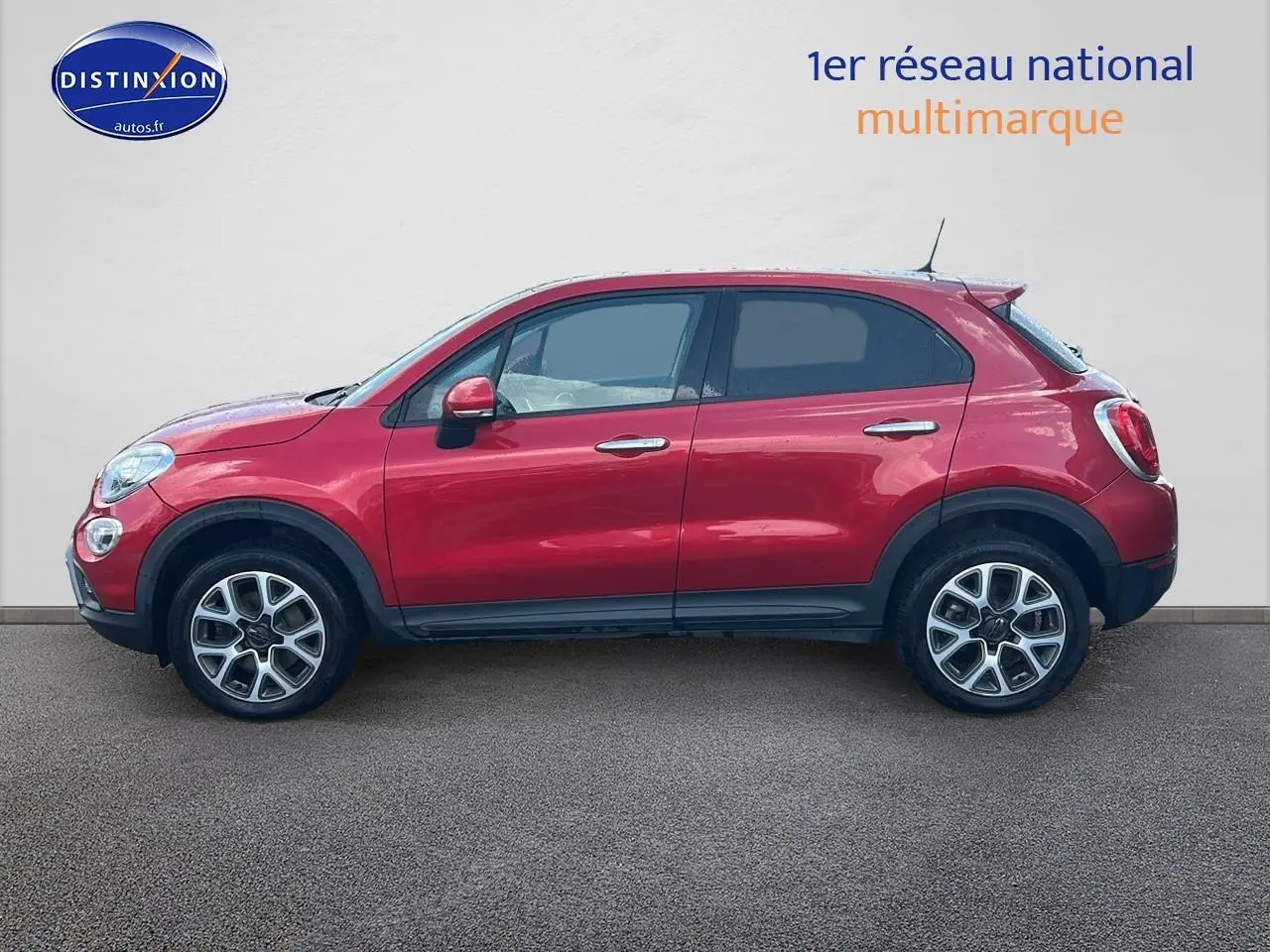 Profil droit d'un FIAT 500X rouge 2016 avec jantes alu et vitres arrière surteintées sur fond neutre.