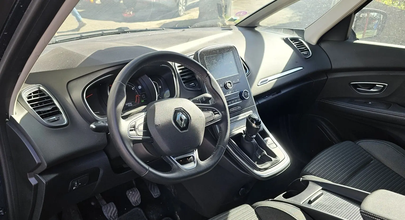 Vue intérieure côté conducteur du Renault Scénic 2020 avec tableau de bord noir et console centrale tactile.
