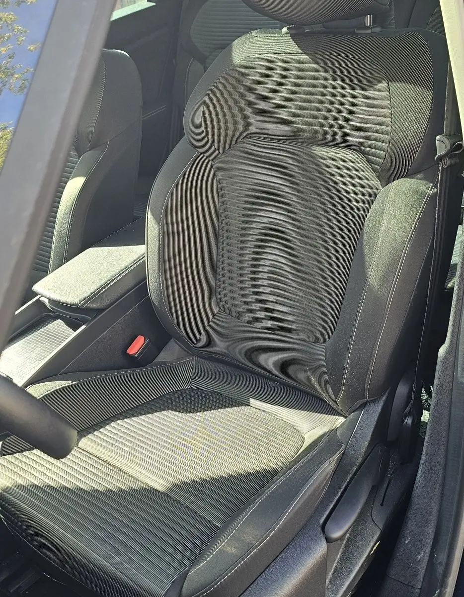 Vue rapprochée du siège conducteur en tissu noir avec surpiqûres grises d'un Renault Scenic bleu cosmos métal 2020.