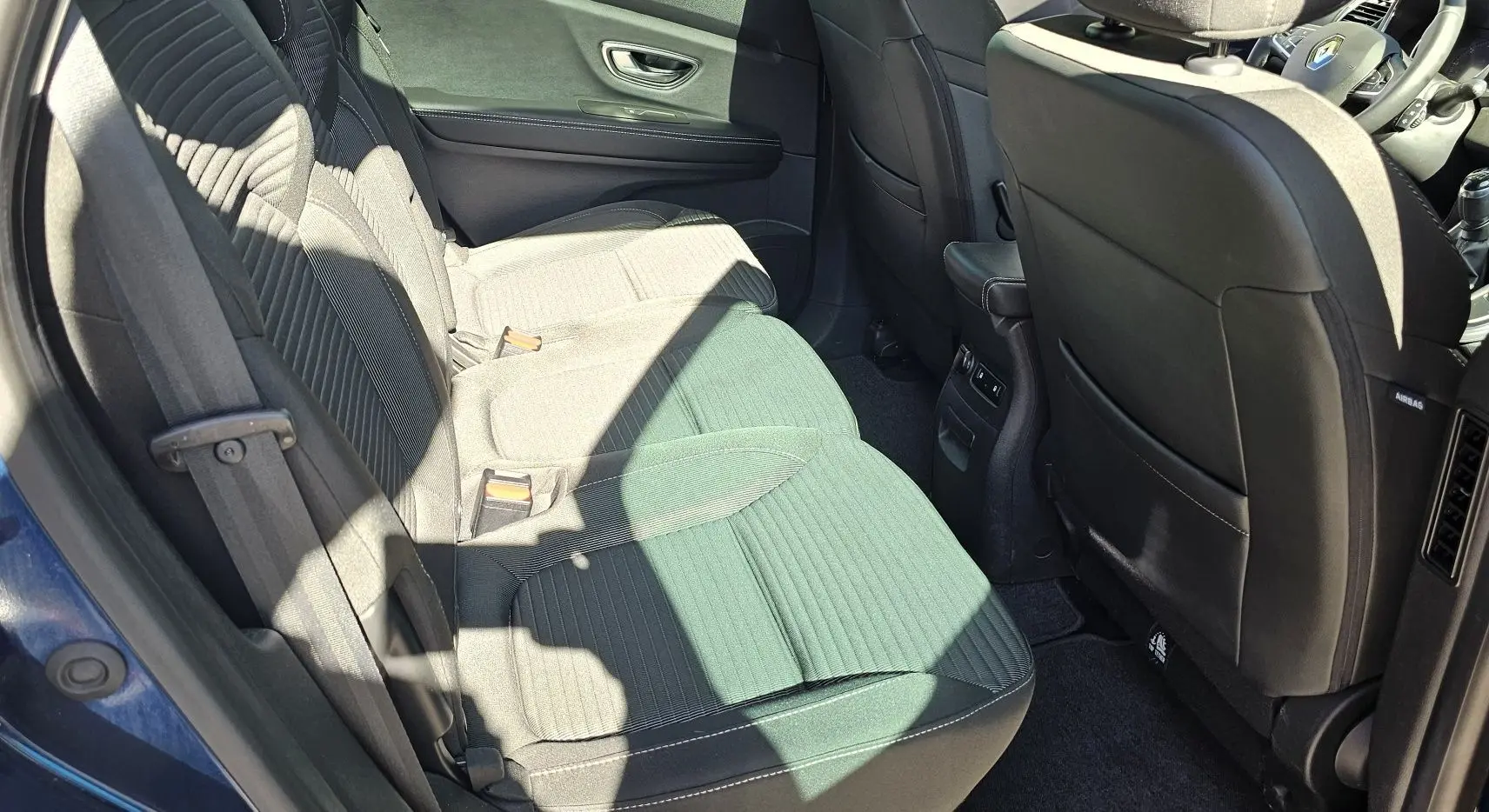 Vue intérieure côté gauche montrant la banquette arrière noire et grise du Renault Scenic 2020 bleu cosmos métal.