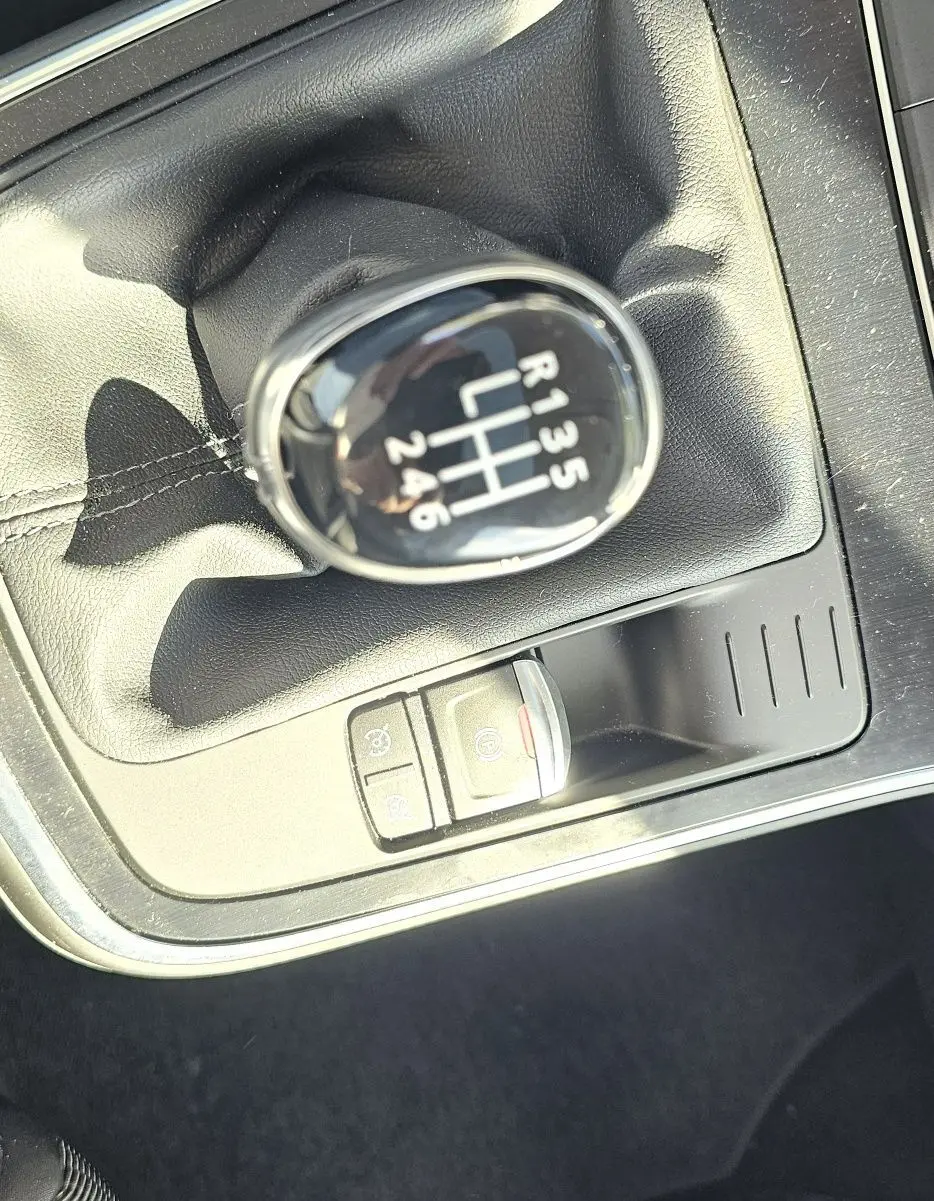 Gros plan sur le levier de vitesse manuel noir du Renault Scenic 1.3 TCE 115CH Business, intérieur tissu gris.